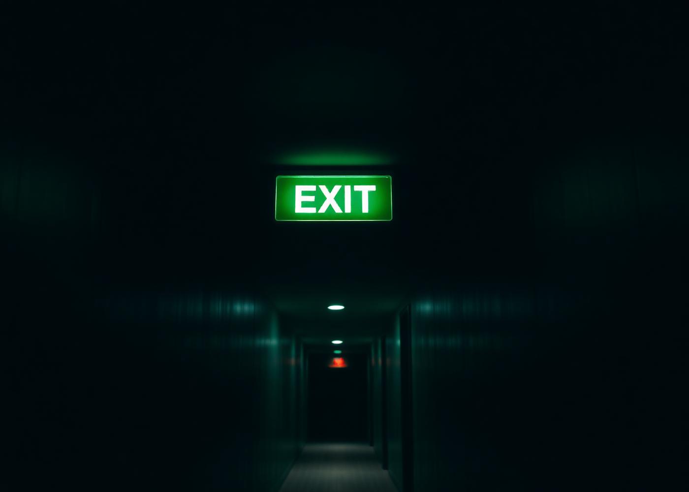 LED emergency exit sign glowing in a hotel corridor